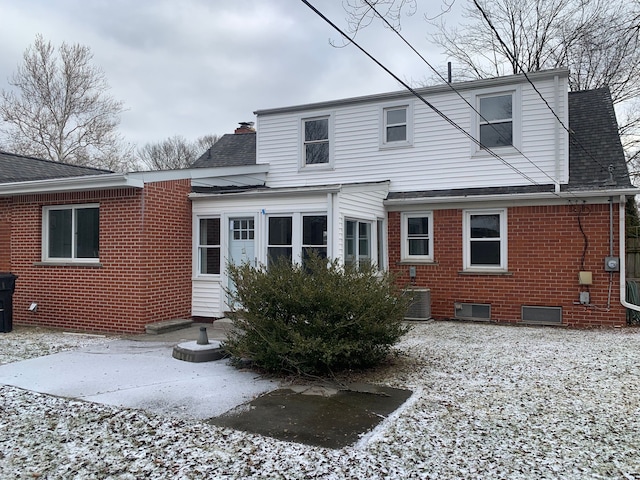 snow covered house featuring central AC unit