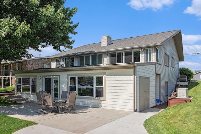 back of property with a yard and a patio area