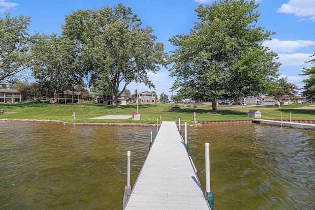 view of dock featuring a water view and a yard