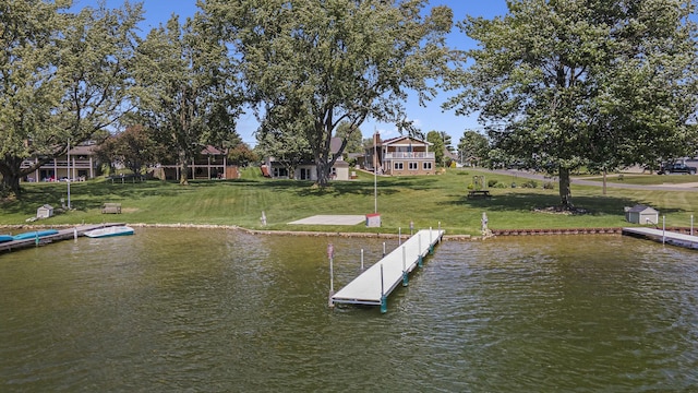 view of dock with a water view and a yard