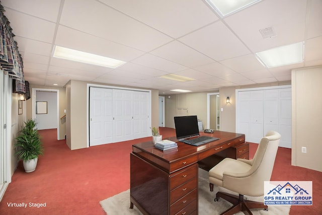 carpeted office with a paneled ceiling