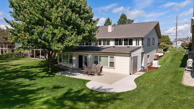 rear view of house with a lawn and a patio area