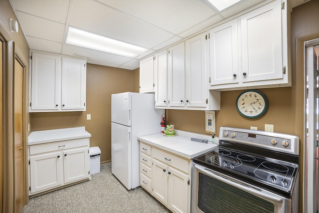 kitchen featuring white cabinetry, stainless steel electric range oven, a paneled ceiling, and white refrigerator