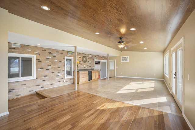 unfurnished living room featuring wood ceiling, ceiling fan, brick wall, and light hardwood / wood-style floors