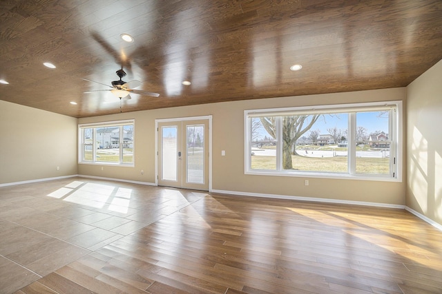 empty room featuring lofted ceiling, wood ceiling, light hardwood / wood-style floors, and french doors