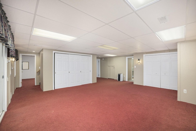 basement with a paneled ceiling and carpet flooring