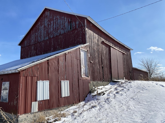 snow covered property with an outbuilding