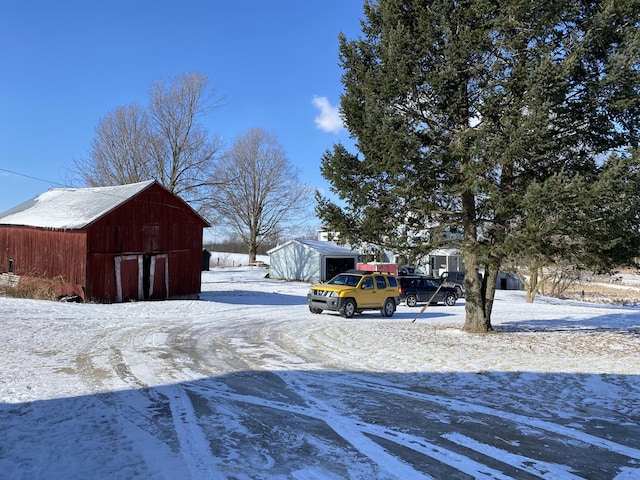 yard layered in snow with an outbuilding