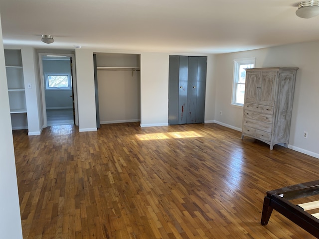 unfurnished bedroom with multiple closets and dark hardwood / wood-style flooring