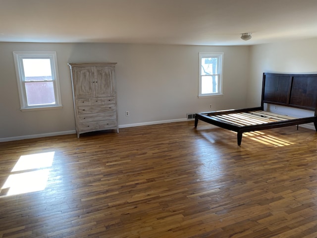 unfurnished bedroom with dark wood-type flooring