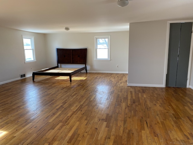 unfurnished bedroom featuring dark wood-type flooring and multiple windows