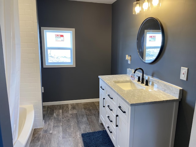 bathroom featuring hardwood / wood-style flooring, vanity, and shower / bath combo