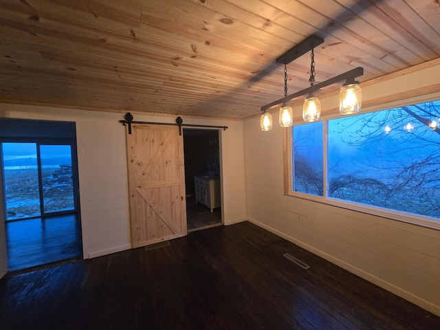 unfurnished room with dark hardwood / wood-style floors, a barn door, and wooden ceiling