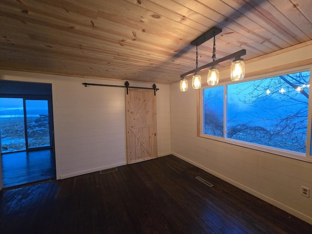 spare room featuring dark wood-type flooring, a barn door, and wooden ceiling