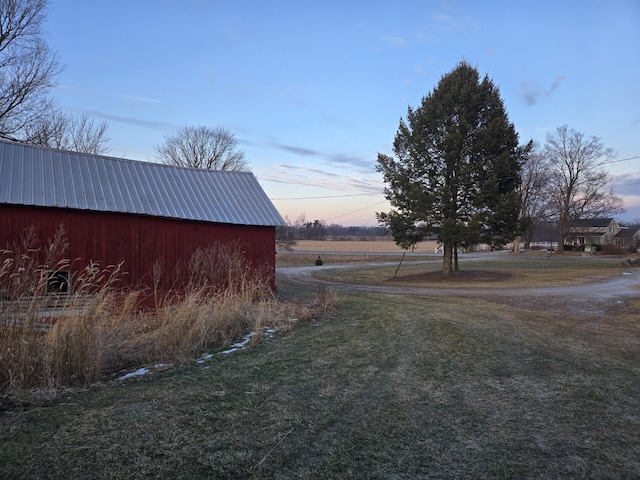 yard at dusk featuring an outbuilding