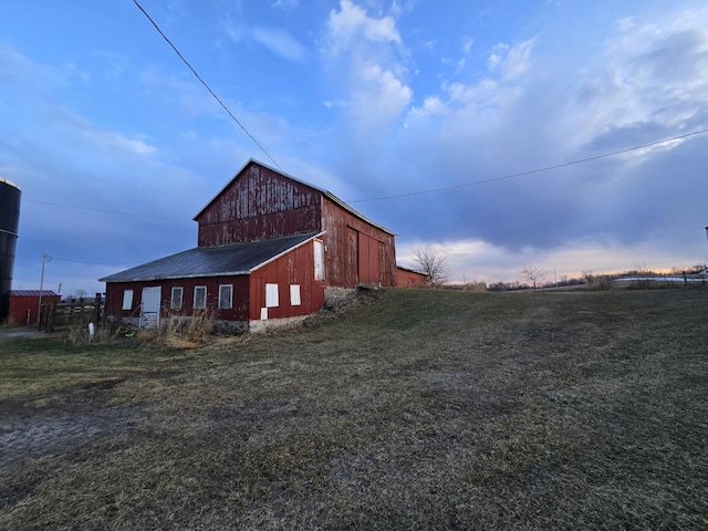 view of side of home featuring an outbuilding and a yard