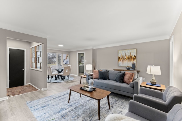 living room with crown molding and light hardwood / wood-style floors