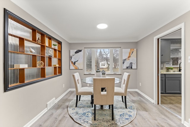 dining space with light hardwood / wood-style floors