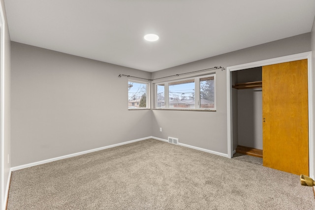 unfurnished bedroom featuring carpet flooring and a closet