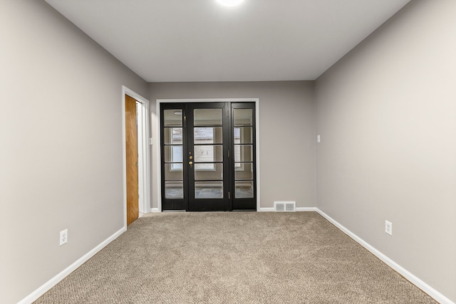 carpeted empty room featuring french doors