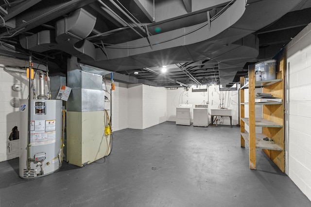 basement with water heater, sink, washer and dryer, and heating unit