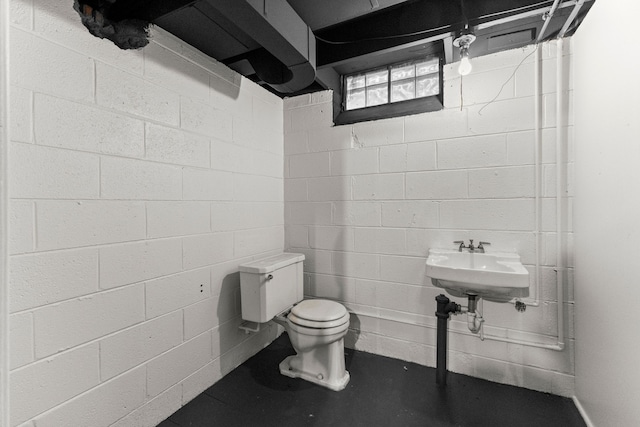 bathroom featuring concrete floors and toilet