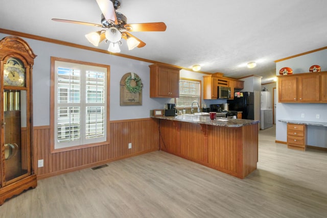 kitchen featuring crown molding, stove, sink, and kitchen peninsula