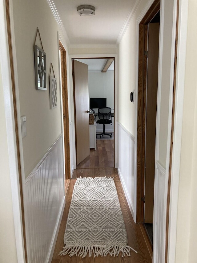 corridor with wood-type flooring and ornamental molding