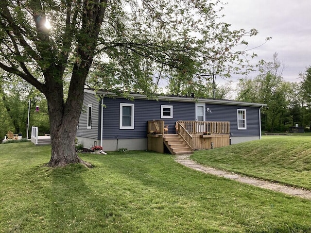 back of property featuring a lawn and a deck