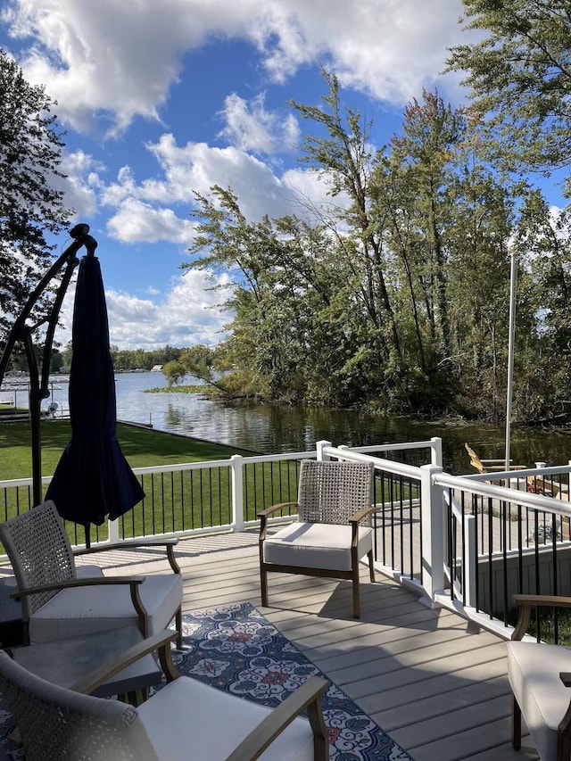 wooden terrace featuring a lawn and a water view