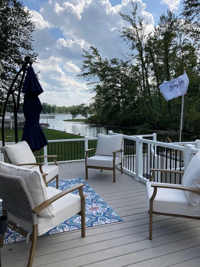 deck featuring a lawn and a water view