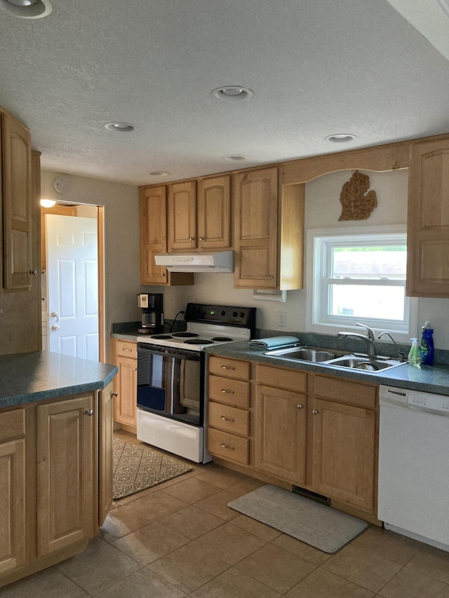 kitchen with sink, light tile patterned floors, a textured ceiling, and white appliances