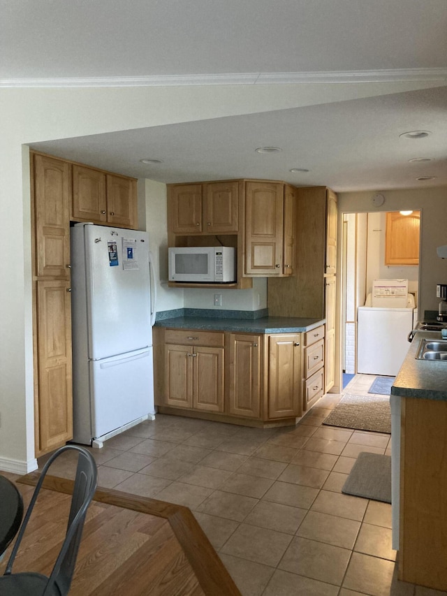 kitchen featuring white appliances, ornamental molding, washer / dryer, and light tile patterned floors