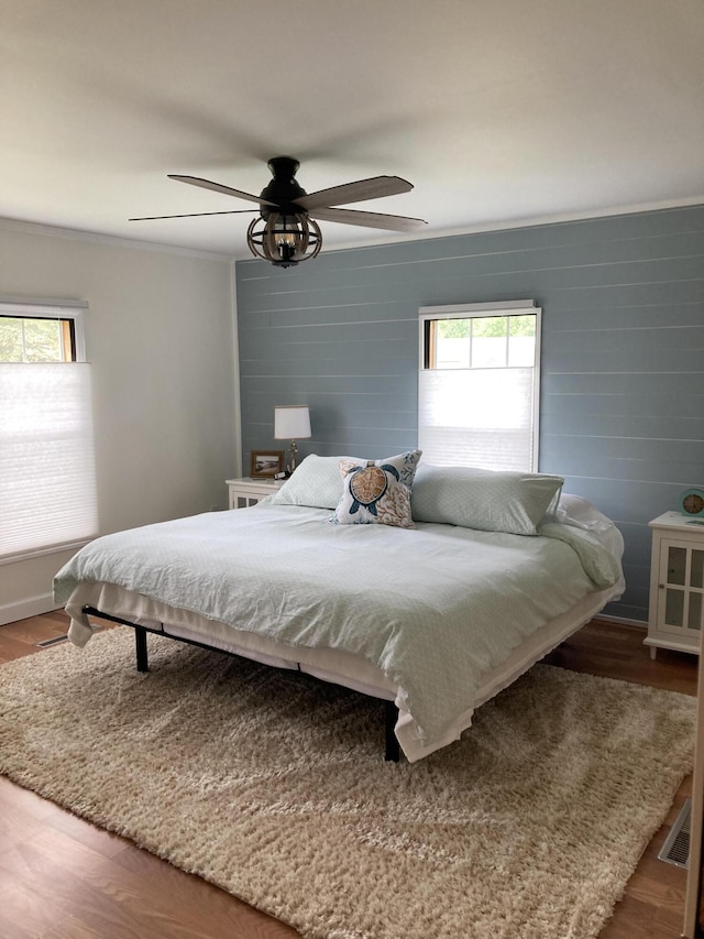 bedroom featuring hardwood / wood-style flooring, ceiling fan, and ornamental molding