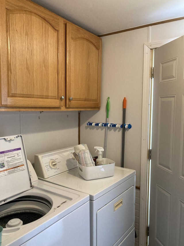 laundry area featuring washer and dryer and cabinets