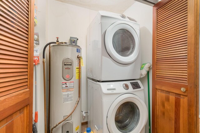 laundry area featuring water heater and stacked washing maching and dryer