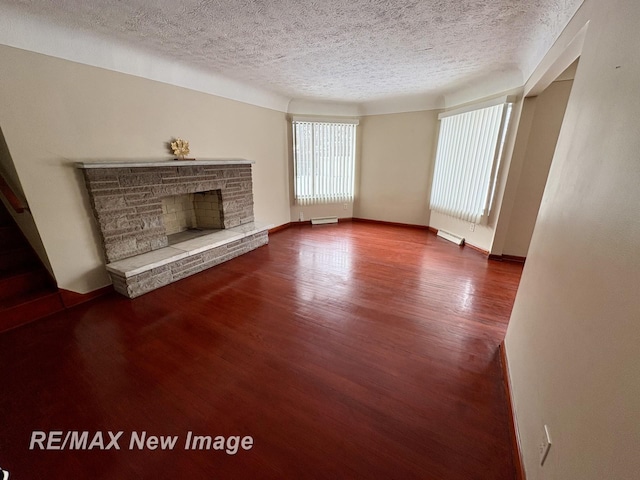 unfurnished living room featuring hardwood / wood-style flooring, a fireplace, and a textured ceiling