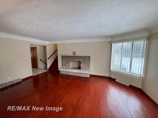 unfurnished living room with hardwood / wood-style floors, a textured ceiling, and a fireplace