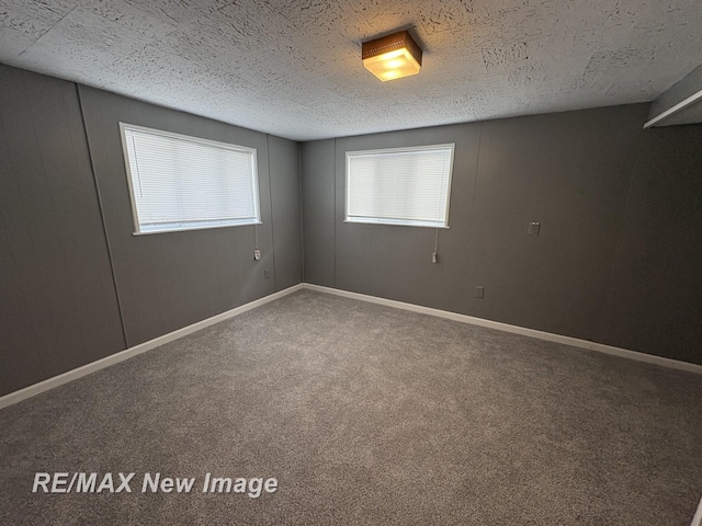 carpeted empty room with a textured ceiling