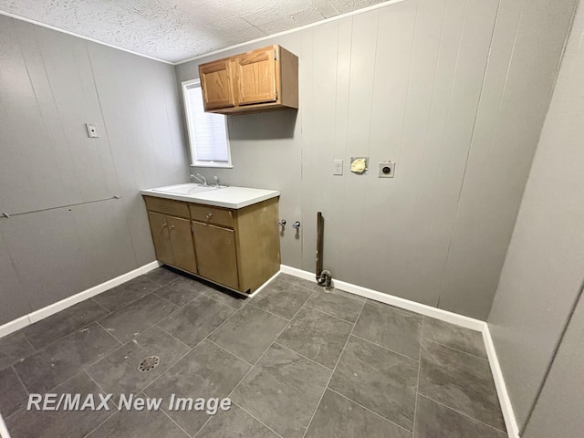 washroom featuring cabinets, hookup for an electric dryer, sink, and a textured ceiling