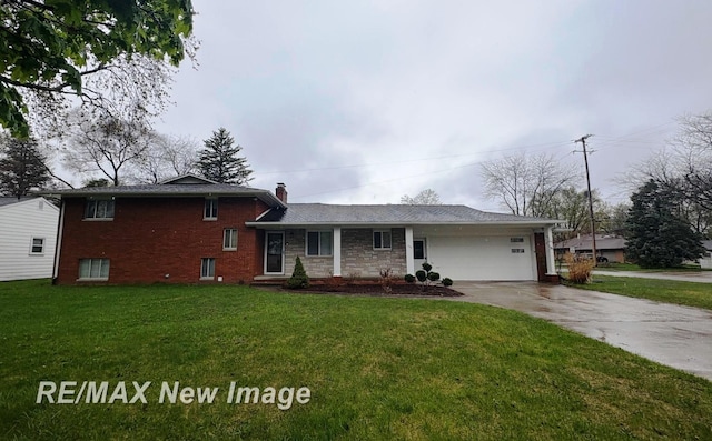 split level home featuring a chimney, brick siding, an attached garage, concrete driveway, and a front lawn