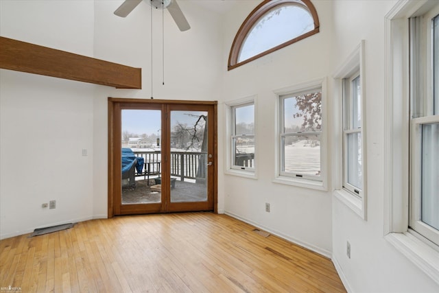 unfurnished sunroom with ceiling fan