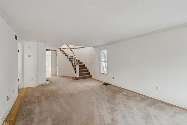 unfurnished living room featuring light colored carpet and ornamental molding