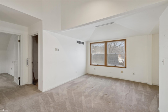 empty room featuring lofted ceiling and light colored carpet