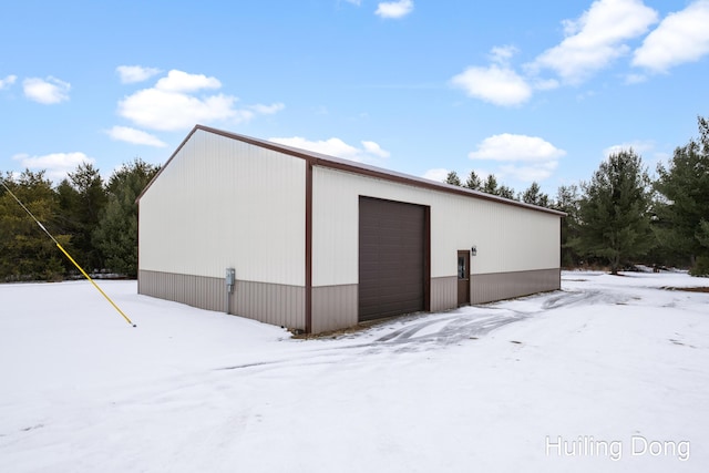 snow covered structure with a garage