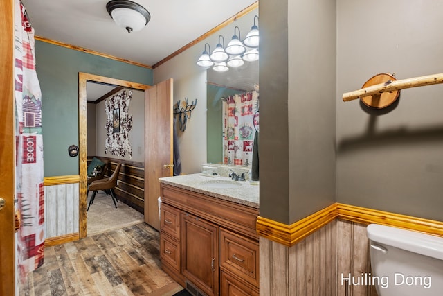 bathroom featuring crown molding, wood-type flooring, vanity, and toilet