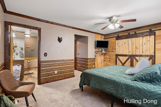 bedroom featuring crown molding, ceiling fan, carpet flooring, a barn door, and wood walls