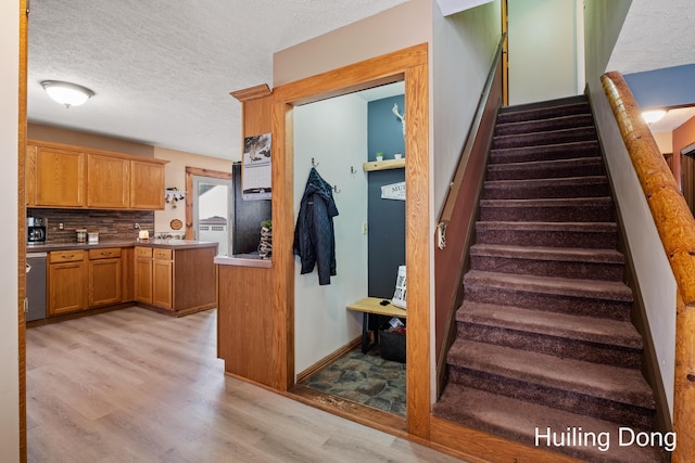 staircase featuring hardwood / wood-style floors and a textured ceiling