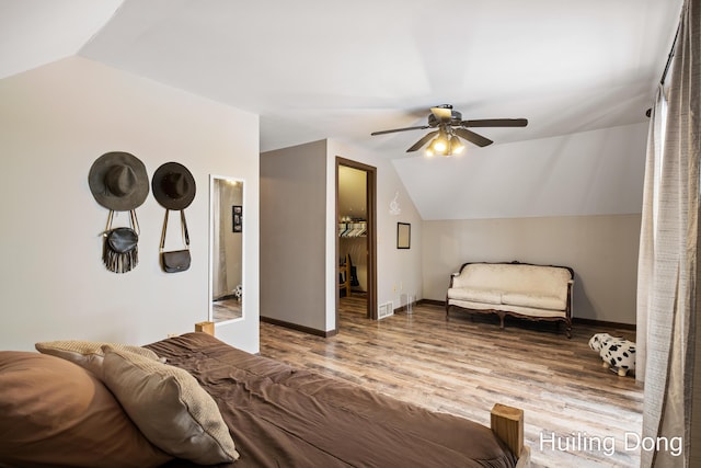 bedroom with a walk in closet, lofted ceiling, hardwood / wood-style floors, and ceiling fan