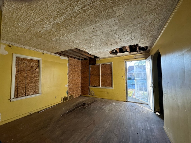 unfurnished living room featuring crown molding and hardwood / wood-style flooring